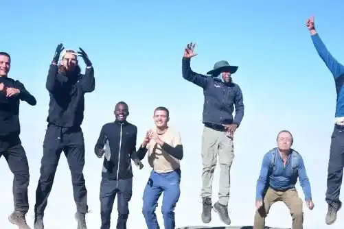 Climbers celebrating at Uhuru Peak on Mount Kilimanjaro