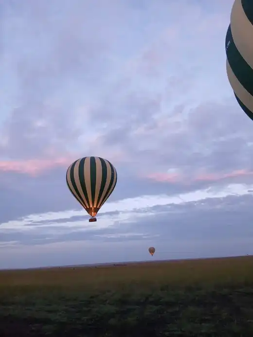 Hot air balloon flying over the Serengeti plains at sunrise