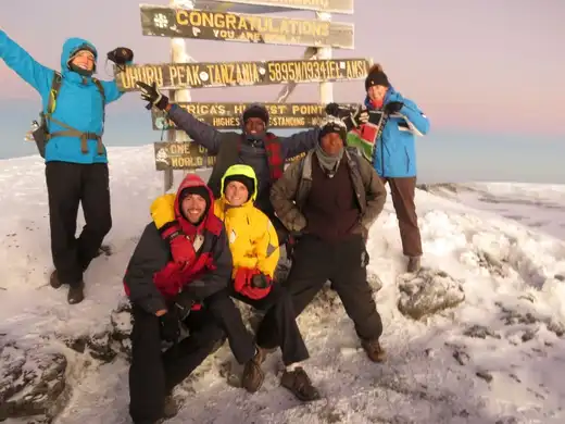Climbers celebrating at Uhuru Peak summit on Mount Kilimanjaro