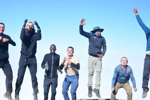 Climbers celebrating at Uhuru Peak summit on Mount Kilimanjaro