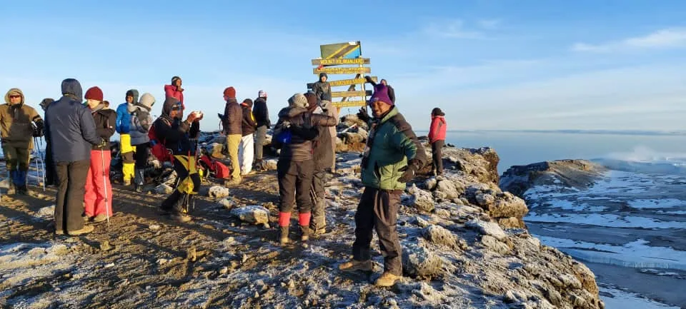 Climbers celebrating at Uhuru Peak summit on Mount Kilimanjaro